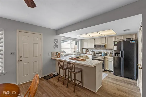 a kitchen with kitchen island a stove a table and chairs