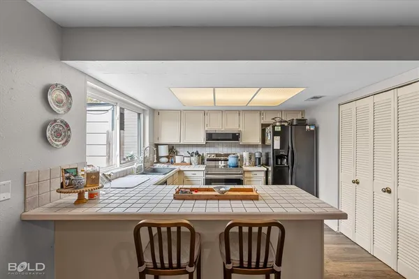 a kitchen with stainless steel appliances a sink stove and microwave