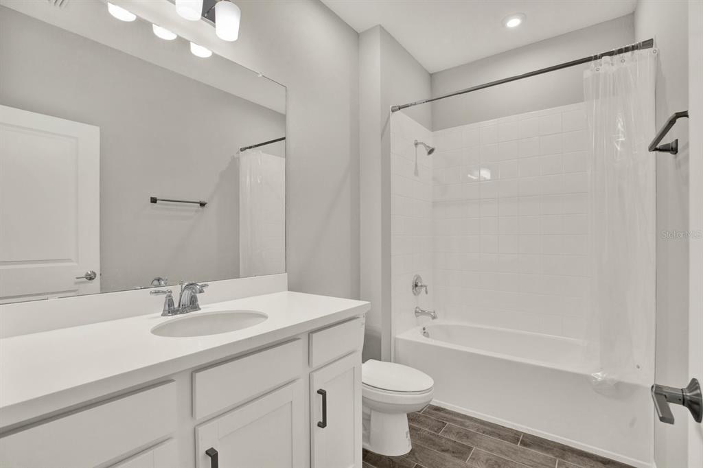 13729 Rangeland Boulevard Odessa, FL 33556 - Photo 16 of 30 a bathroom with a sink toilet a mirror and shower