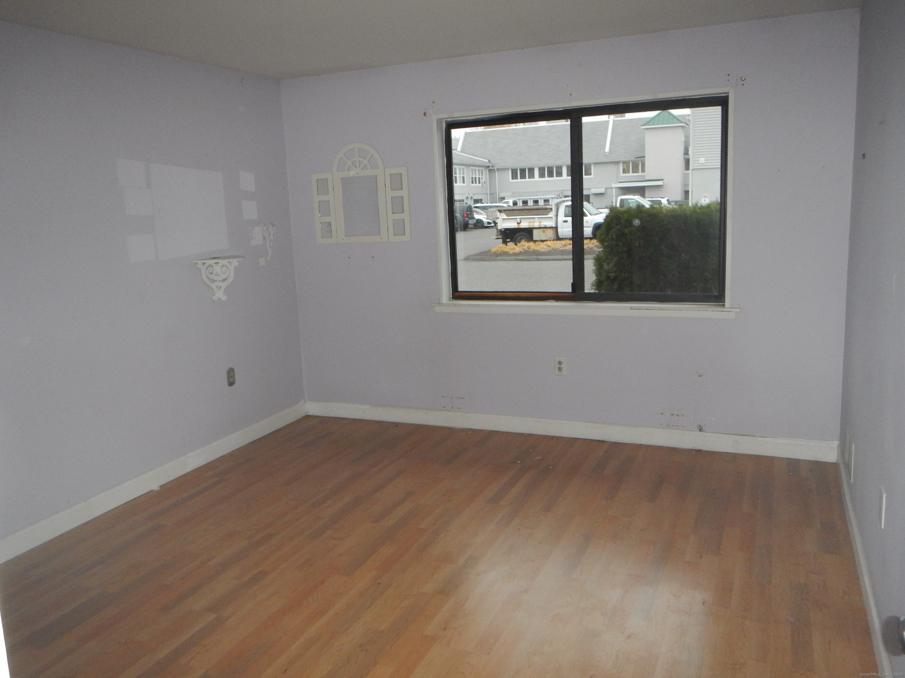 444 Asbury Ridge, Unit 444 Shelton, CT 06484 - Photo 3 of 7 a view of an empty room with wooden floor and a window