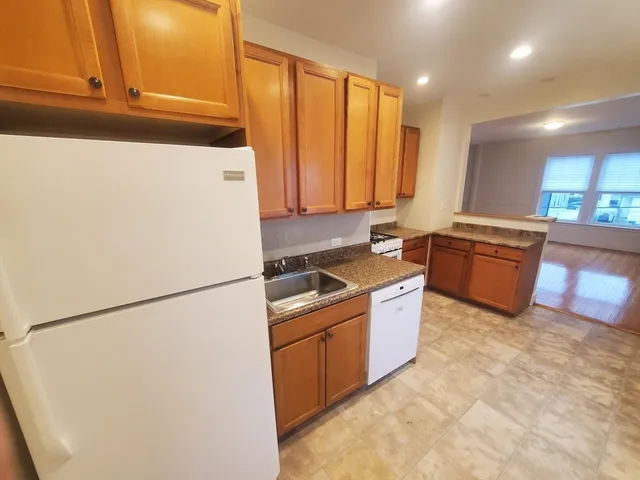 a kitchen with granite countertop a sink and a refrigerator