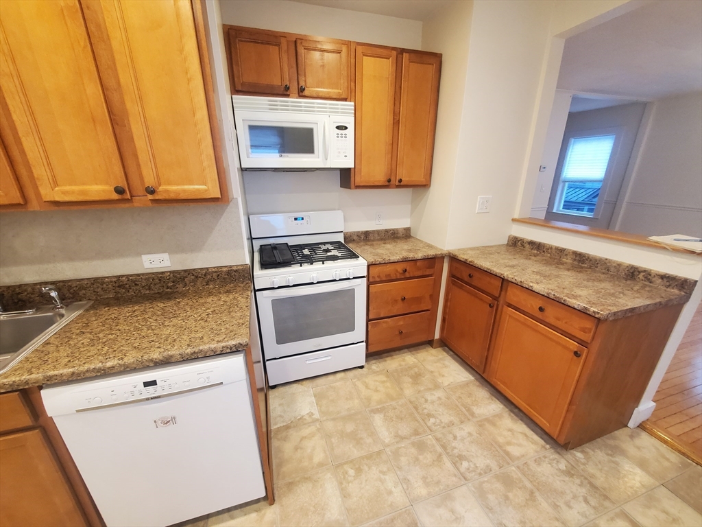 68 Nahant Avenue, Unit 2 Boston, MA 02122 - Photo 3 of 19 a kitchen with stainless steel appliances granite countertop a stove a sink and a microwave