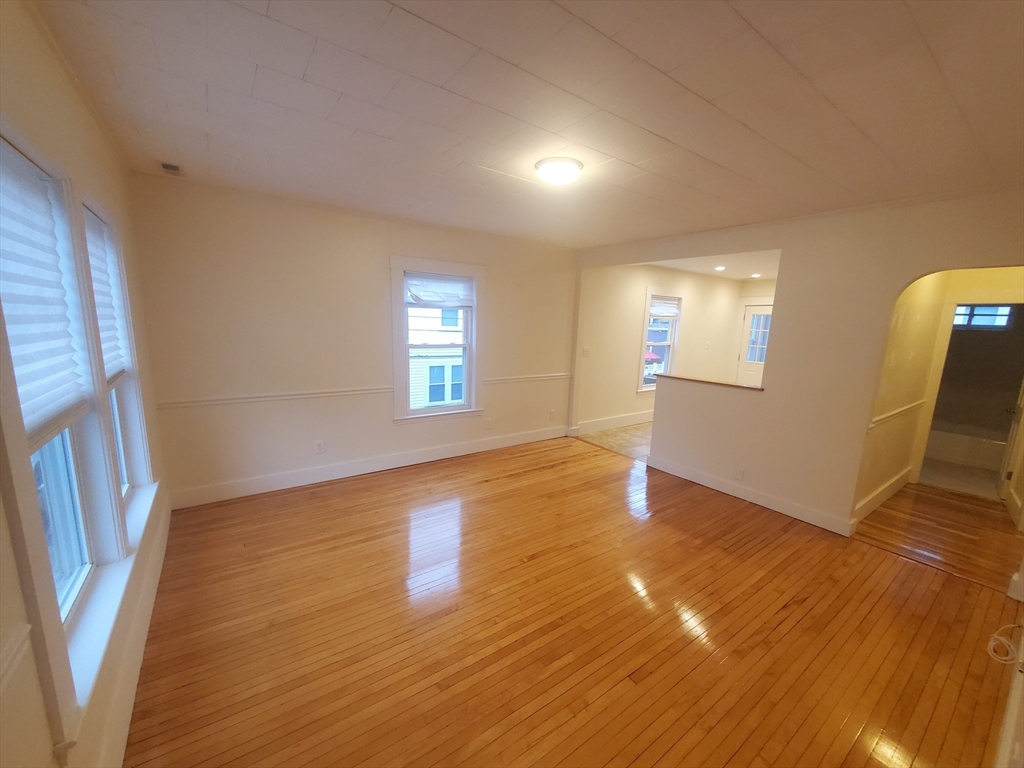 68 Nahant Avenue, Unit 2 Boston, MA 02122 - Photo 4 of 19 a view of an empty room with wooden floor and a window