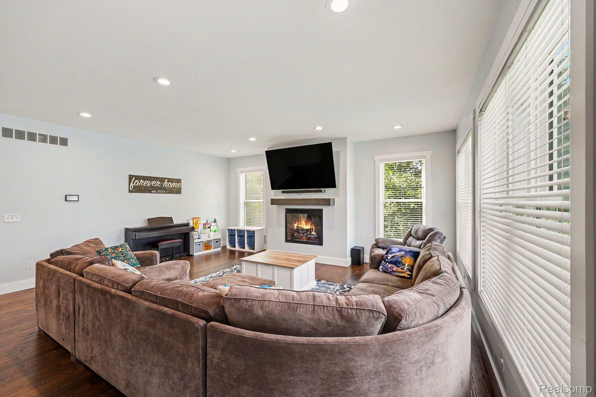 1660 Winthrop Road Bloomfield Hills, MI 48302 - Photo 7 of 38 Spacious living area featuring dark wood-finish flooring, recessed lighting, and a modern fireplace with a wood mantel