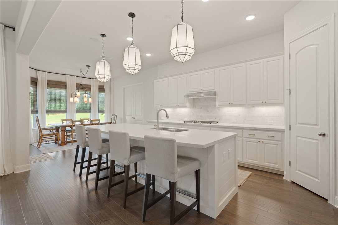 a kitchen with center island white cabinets stainless steel appliances and dining table
