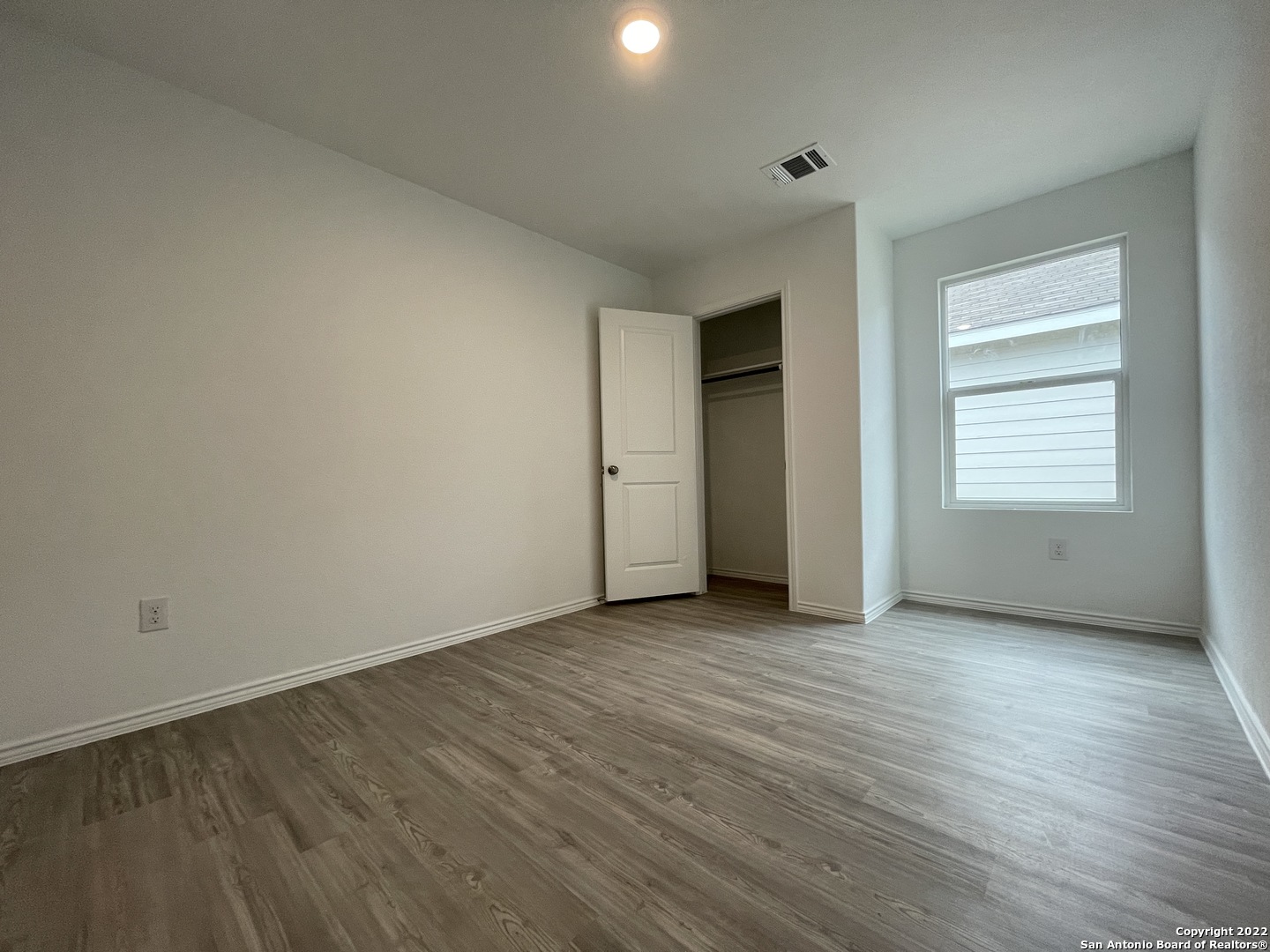 4324 Levee Ridge San Antonio, TX 78223 - Photo 15 of 24 an empty room with wooden floor and windows