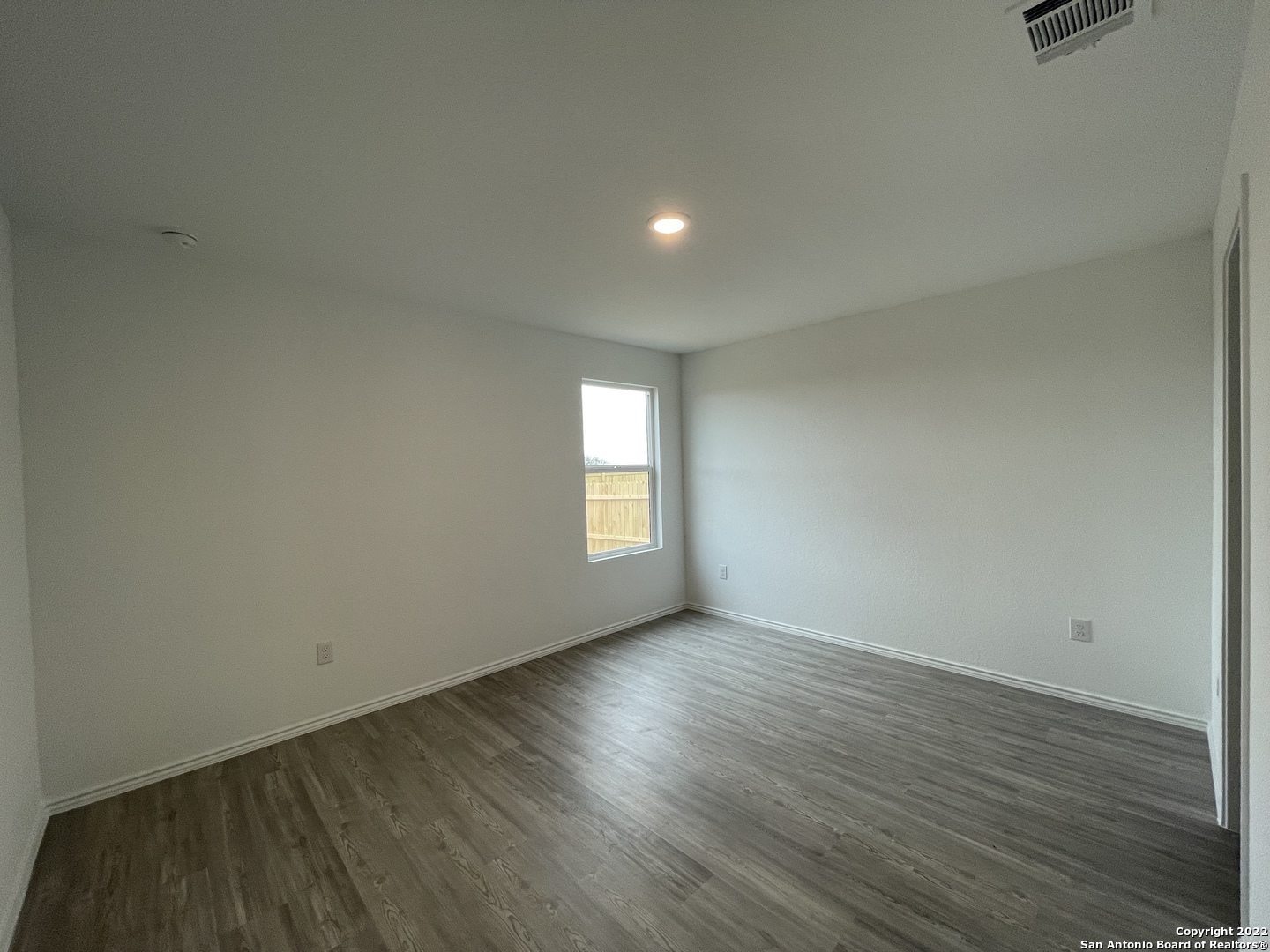 4324 Levee Ridge San Antonio, TX 78223 - Photo 5 of 24 an empty room with wooden floor and windows