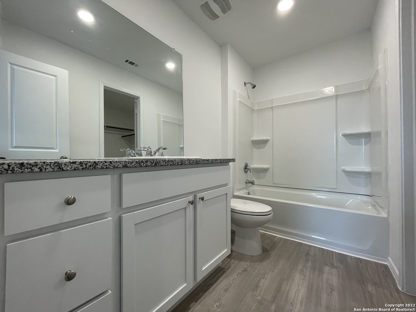 4324 Levee Ridge San Antonio, TX 78223 - Photo 7 of 24 a bathroom with a granite countertop toilet a sink and a mirror