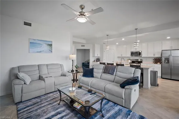 a kitchen with a dining table chairs stainless steel appliances and cabinets