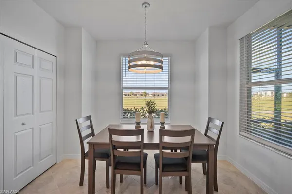 a dining room with furniture a chandelier and window