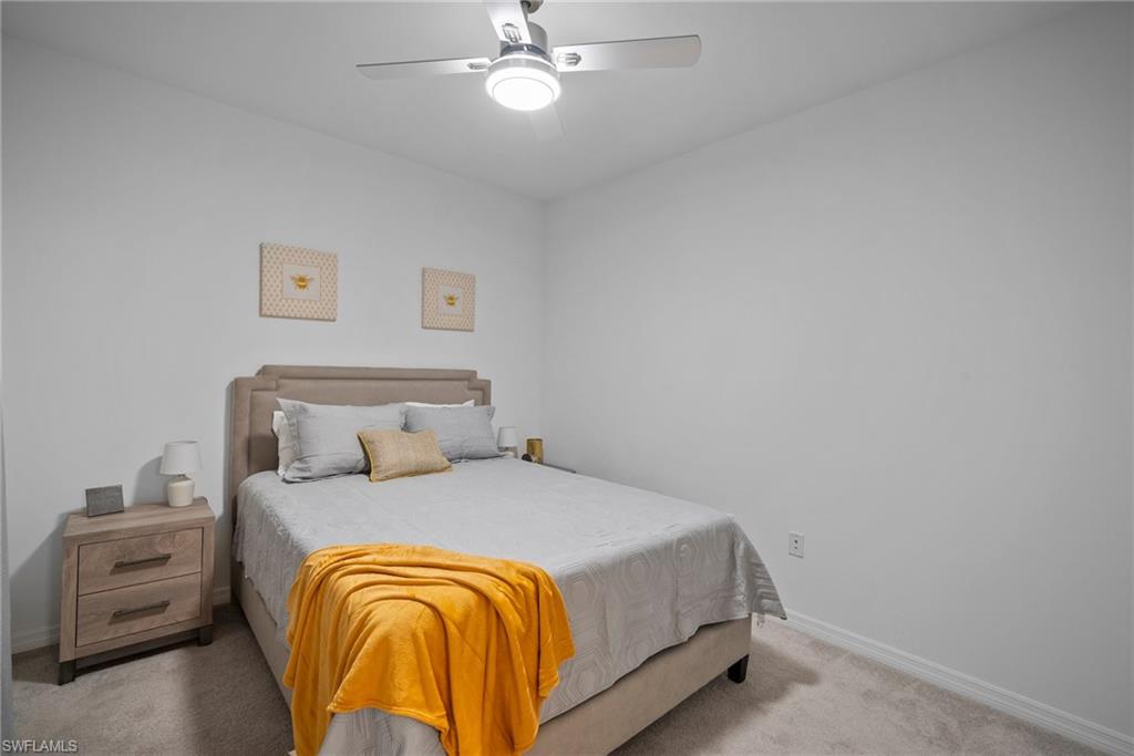 15980 Grassland Lane, Unit 2914 Babcock Ranch, FL 33982 - Photo 19 of 29 a bedroom with a bed and a chandelier