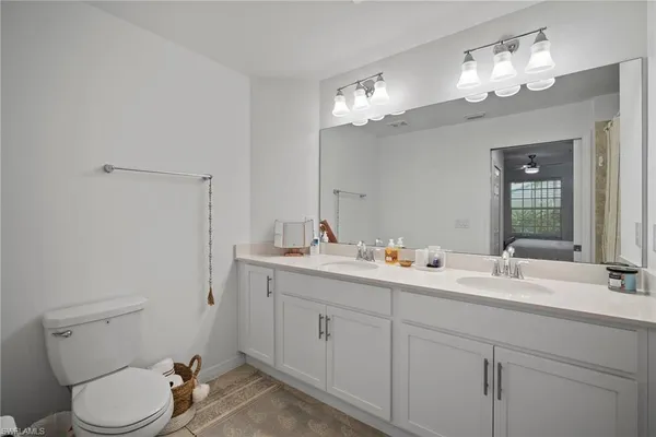 a en suite bathroom with a double vanity sink and a mirror