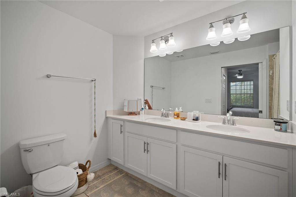15980 Grassland Lane, Unit 2914 Babcock Ranch, FL 33982 - Photo 25 of 29 a bathroom with a toilet a sink and mirror
