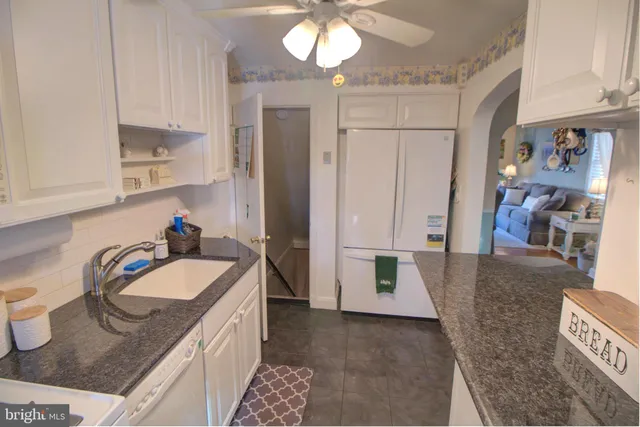 a spacious bathroom with a granite countertop sink and a mirror