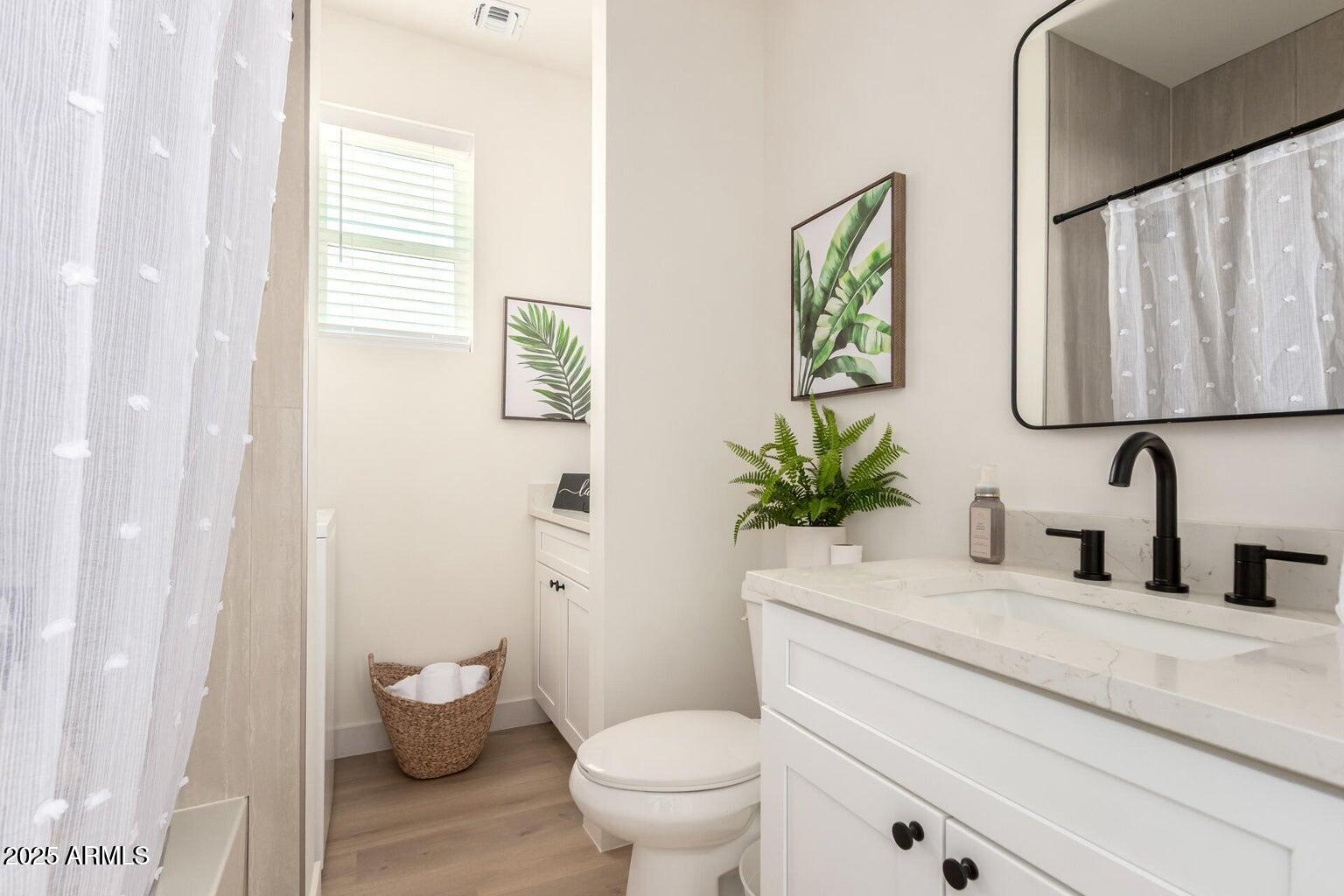 1508 West Sherman Street, Unit B Phoenix, AZ 85007 - Photo 13 of 16 a bathroom with a toilet a sink and a window