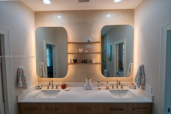 a bathroom with double vanity sinks and a mirror
