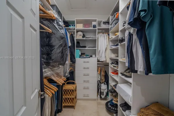 a view of walk in closet with clothes and shoes