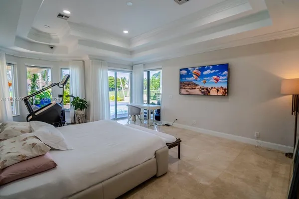 a bedroom with a bed a couch and paintings on the wall