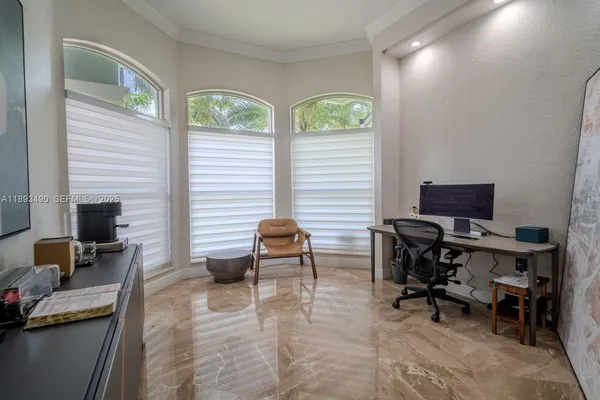 a view of a workspace with furniture and a window