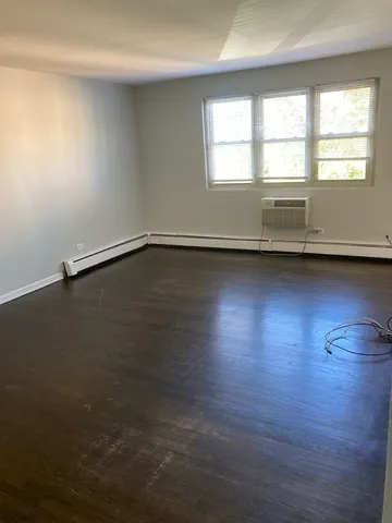 en empty room with wooden floor and windows