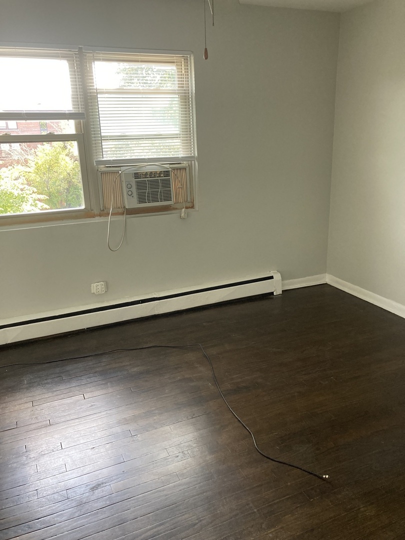 2420 West Berwyn Avenue, Unit 304 Chicago, IL 60625 - Photo 4 of 9 a view of a room with wooden floor and windows