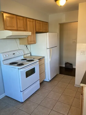 a kitchen with a stove top oven a sink and a refrigerator