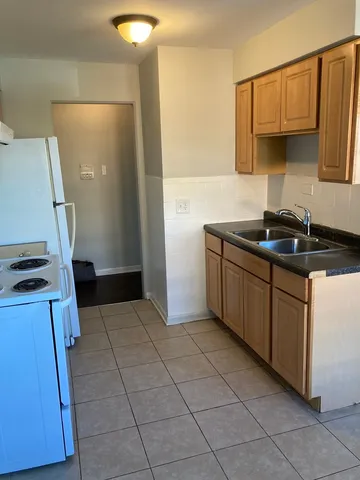 a kitchen with a sink a stove and a refrigerator