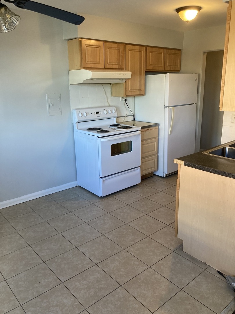 2420 West Berwyn Avenue, Unit 304 Chicago, IL 60625 - Photo 8 of 9 a kitchen with stainless steel appliances a stove a sink and a refrigerator