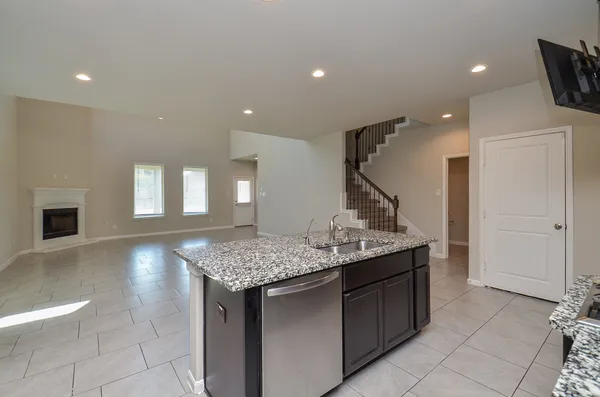 a kitchen with a sink a counter space and wooden floor