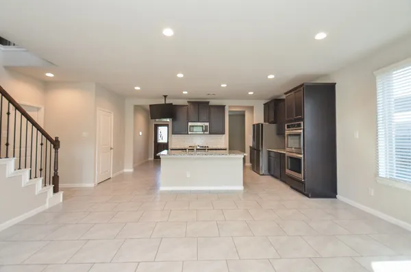 a view of kitchen with stainless steel appliances refrigerator and window