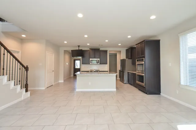 a view of kitchen with stainless steel appliances refrigerator and window