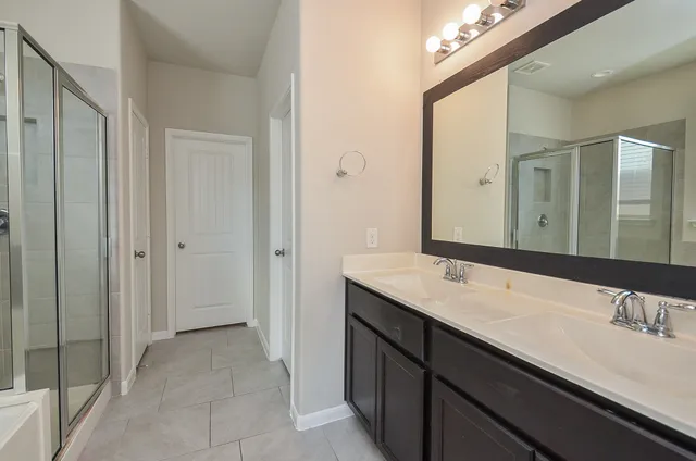 a bathroom with a double vanity sink and a mirror