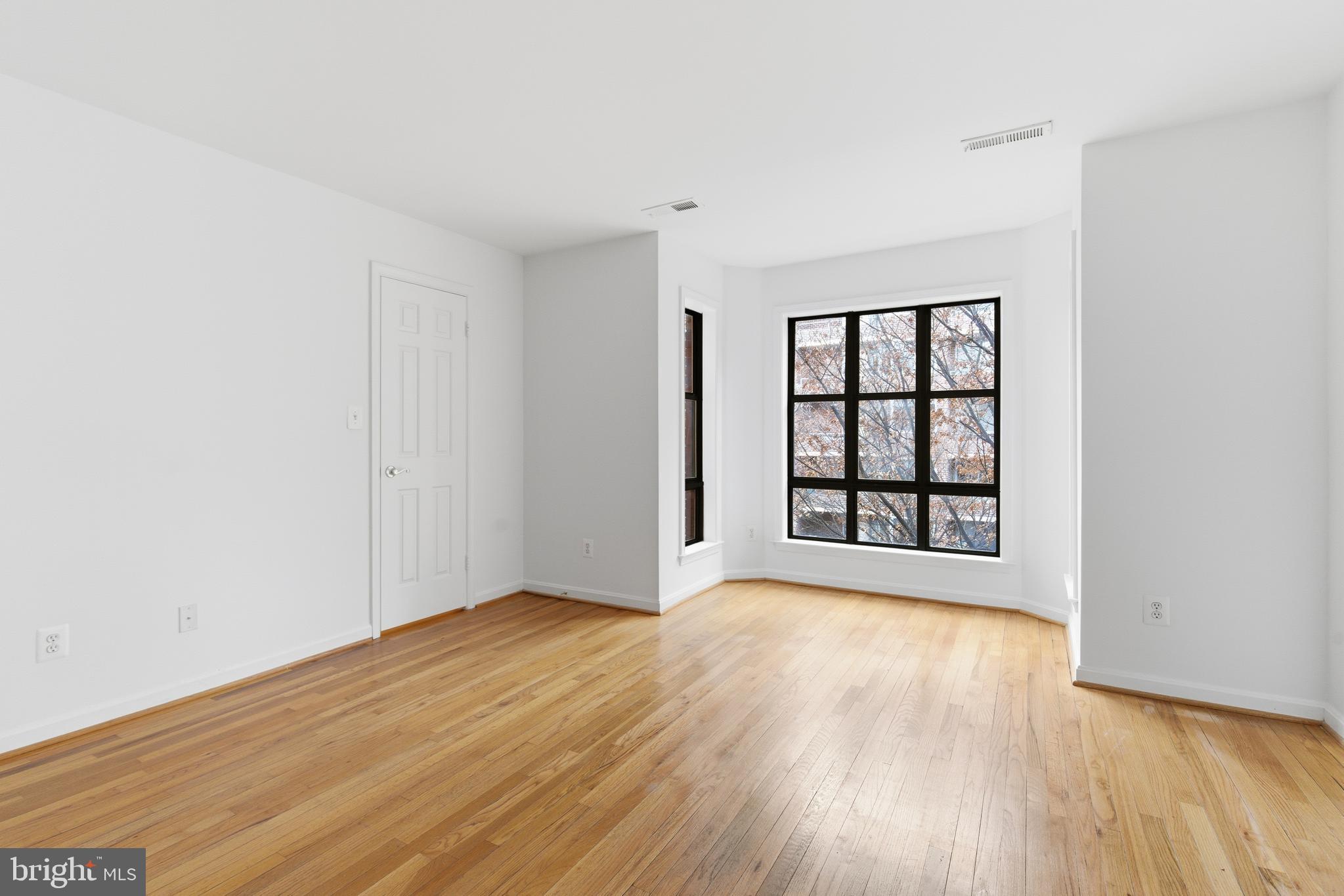 1203 N Street Northwest, Unit E Washington, DC 20005 - Photo 14 of 24 wooden floor in an empty room with a window
