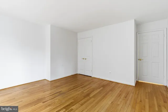 a view of empty room with wooden floor