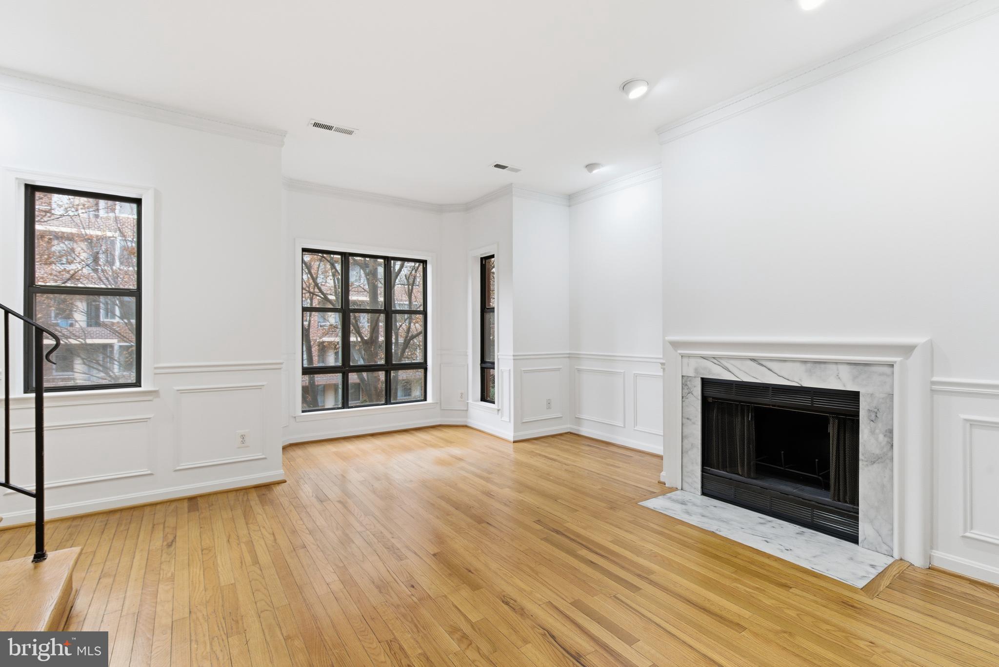 1203 N Street Northwest, Unit E Washington, DC 20005 - Photo 2 of 24 a view of an empty room with a fireplace and a window