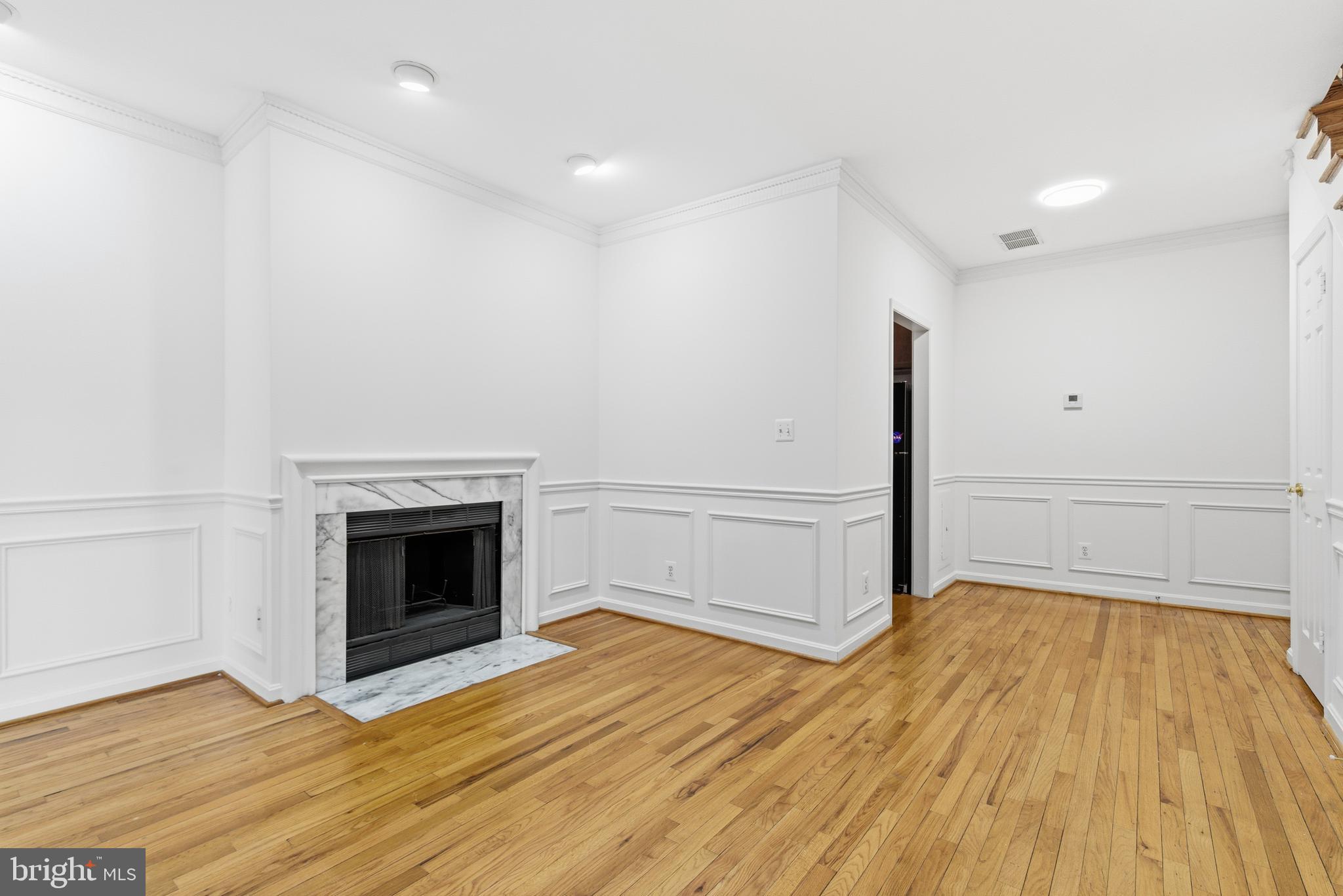 1203 N Street Northwest, Unit E Washington, DC 20005 - Photo 5 of 24 a view of empty room with wooden floor and fireplace
