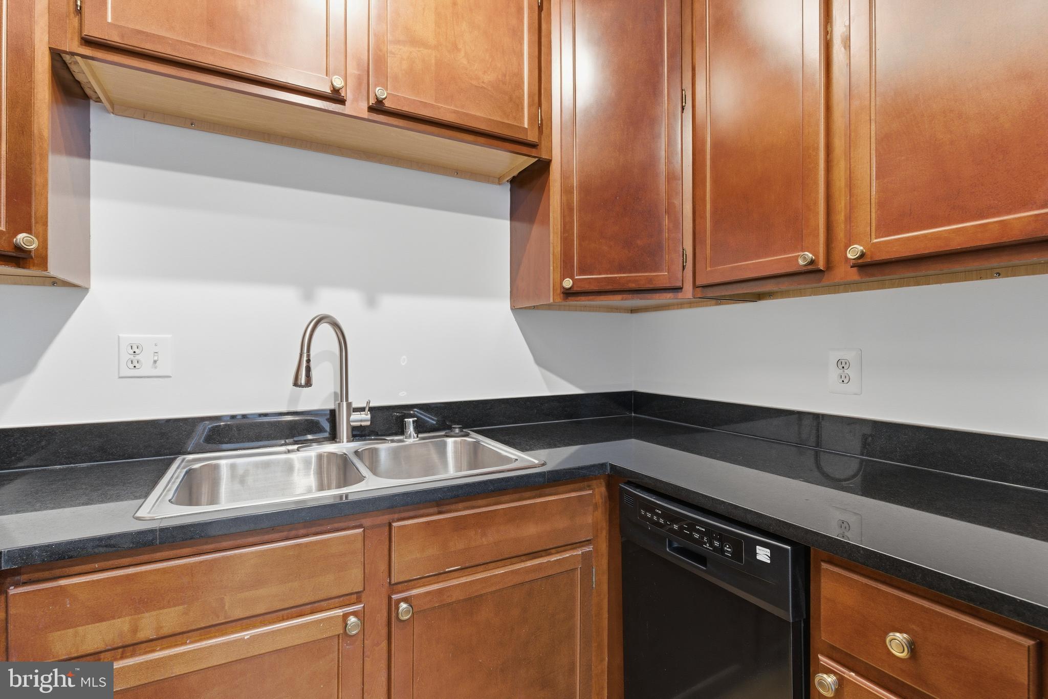 1203 N Street Northwest, Unit E Washington, DC 20005 - Photo 8 of 24 a kitchen with granite countertop a sink and cabinets