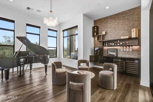 a living room with furniture wooden floor and floor to ceiling windows