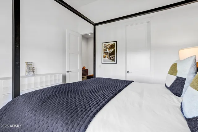 a bedroom with a bed and a painting on the wall