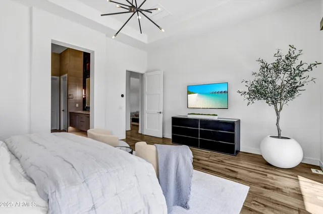 a bedroom with a bed and a chandelier