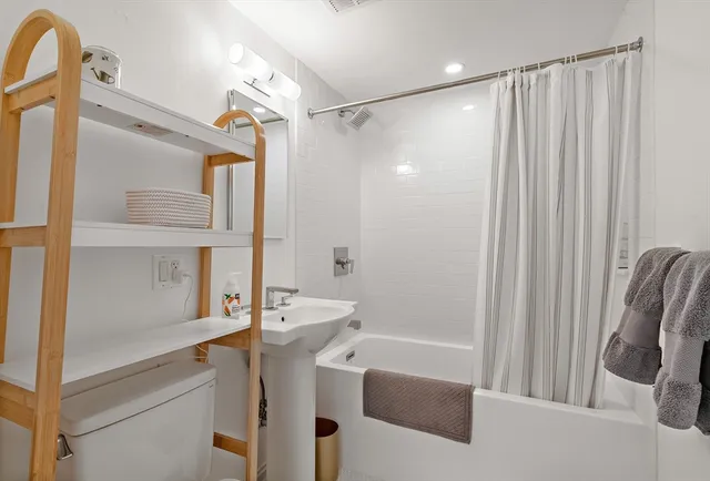 a bathroom with a shower curtain and a sink