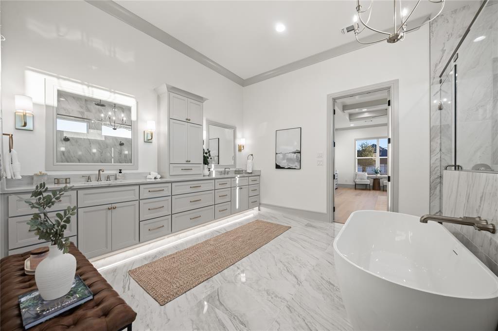 724 Cooper Trail Weatherford, TX 76087 - Photo 27 of 37 Spacious bathroom featuring a freestanding soaking tub, large vanity with dual sinks, built-in cabinetry, and tile flooring