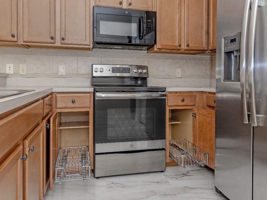 11649 Tempest Harbor Loop Venice, FL 34292 - Photo 5 of 39 a kitchen with stainless steel appliances granite countertop a refrigerator stove and sink