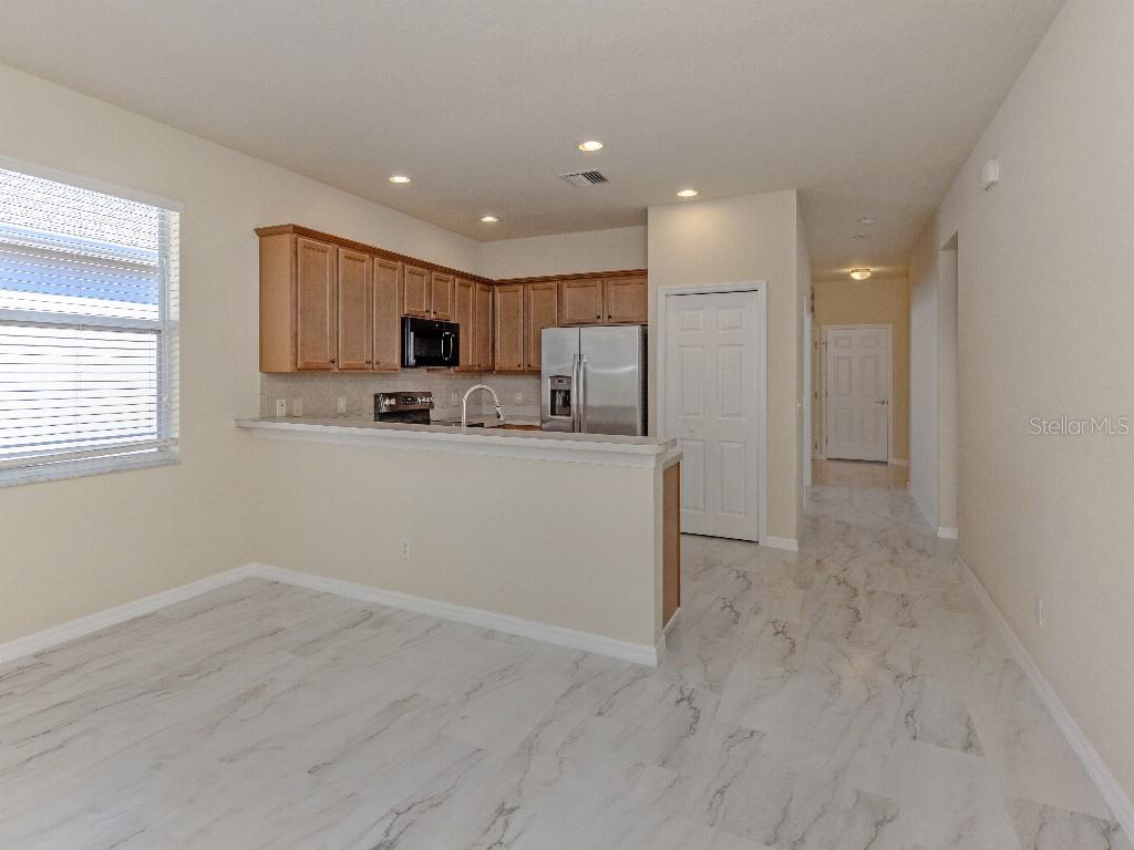 11649 Tempest Harbor Loop Venice, FL 34292 - Photo 9 of 39 a kitchen with a refrigerator and a stove top oven