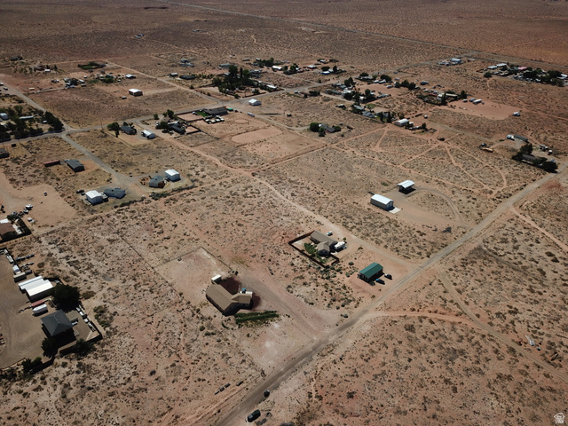 113 5th Avenue, Unit 113 Kanab, UT 84741 - Photo 4 of 13 Expansive desert landscape with scattered residential properties, featuring a mix of single-story homes and outbuildings