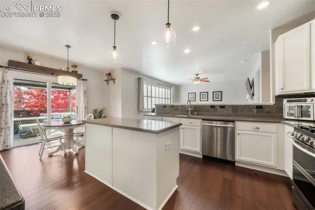 a large kitchen with stainless steel appliances kitchen island granite countertop a sink a stove counter space and cabinets