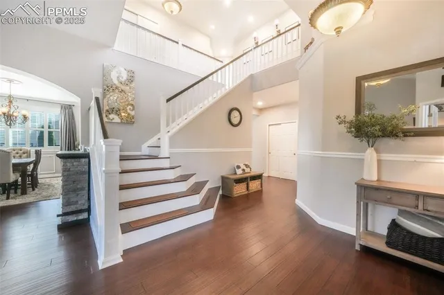 a living room with wooden floor and a chandelier