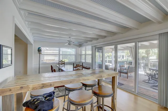 a dining hall with stainless steel appliances granite countertop a sink and a large window