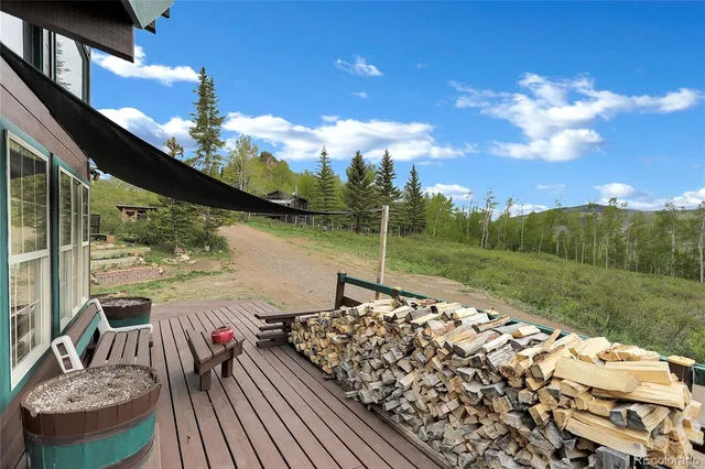 a view of a house with a yard and trees in the background