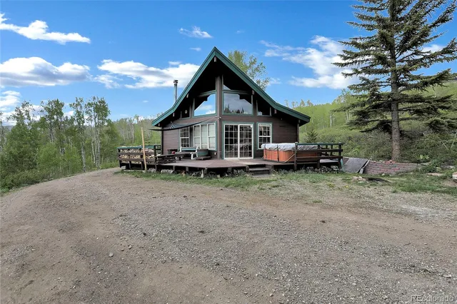 a view of house with green field and trees
